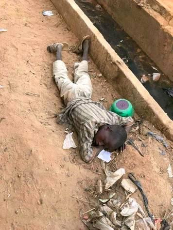 Almajiri boy sleeping on a pile of dirt