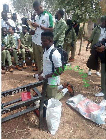 NYSC member kneeling as punishment
