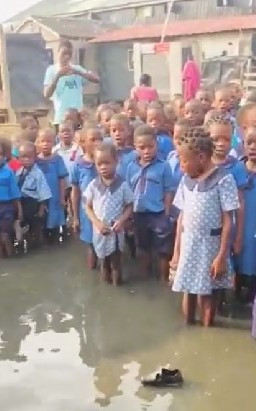 Children sing anthem in flooded hall