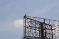 Man Climbs Billboard Hanger, Vows To Jump Down Unless Buhari Resigns Within 12 Hours (Photos)