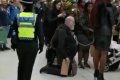 Shocking: Young Woman Seen Dragging Old Man With Chain Through Busy Railway Station (Photos)